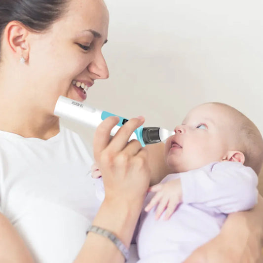 Mother using the electric nasal aspirator on her baby